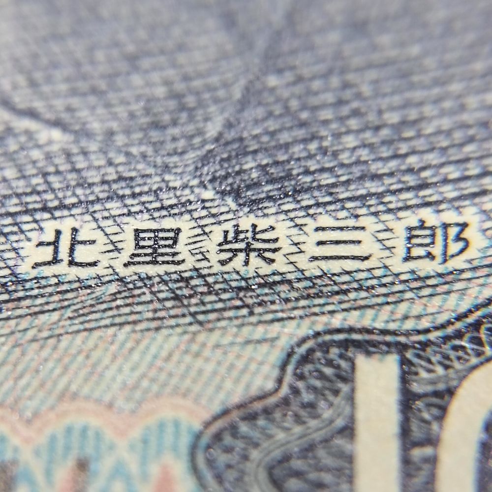 千円札に描かれた人物の名前を30倍ルーペ(拡大鏡)で拡大。